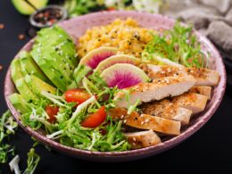 Healthy salad with chicken, tomatoes, avocado, lettuce, watermelon radish and lentil