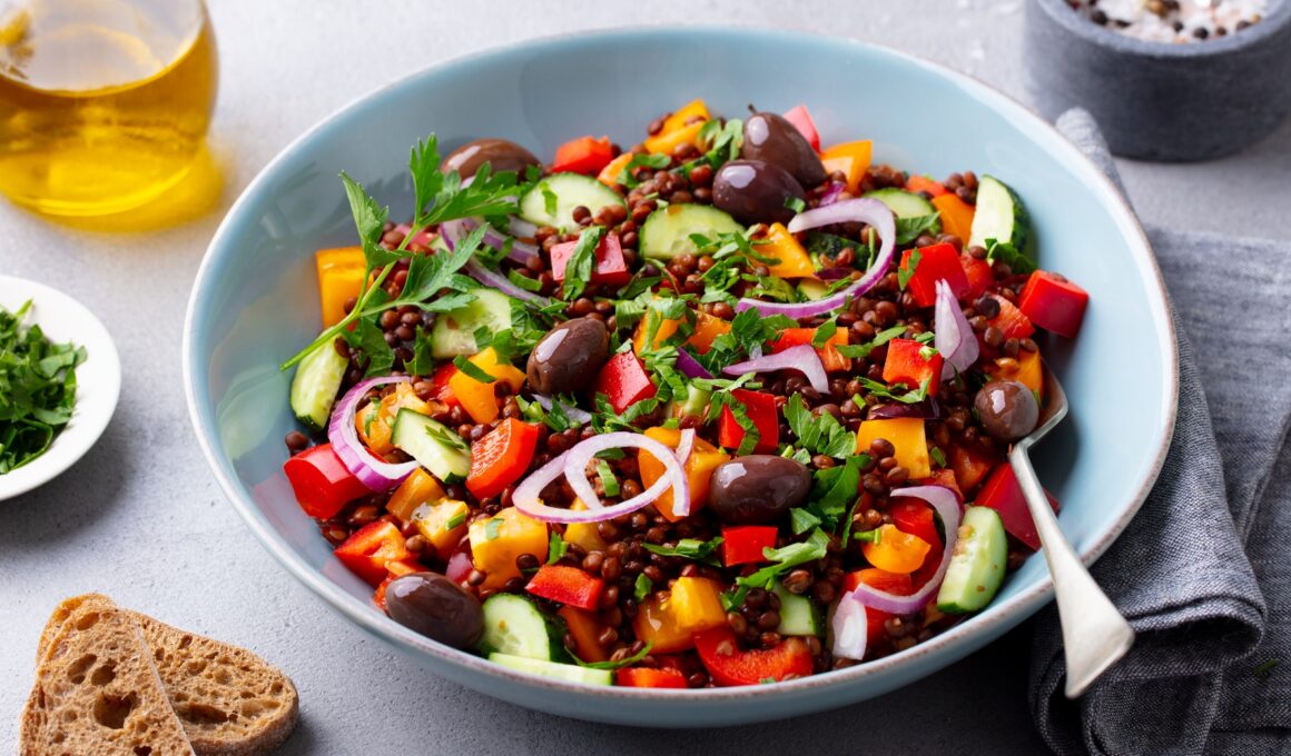 Lentil Salad with Mix Vegetables in bowl. Grey Background.